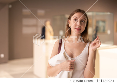 Girl view pictures and icons in museum hall 121480023