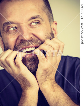Man biting his nails 121480321