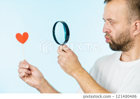 Uncertain man looking at love heart 121480486