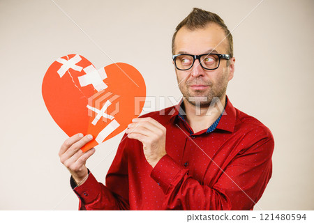Thinking adult man holding broken heart Thinking adult man holding broken heart 121480594