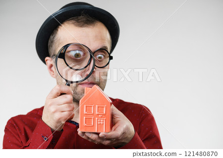Man magnifying red house 121480870