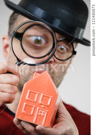 Man magnifying red house 121480873