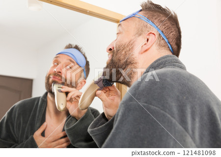 Man shaving trimming his beard Man shaving trimming his beard 121481098