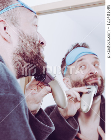 Man shaving trimming his beard 121481099
