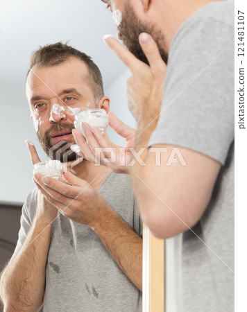 Man applying moisturizer cream in bathroom Man applying moisturizer cream in bathroom 121481107