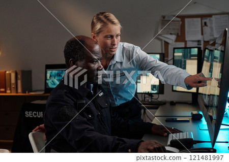 Female guard pointing at cctv on screen Female guard pointing at cctv on screen 121481997
