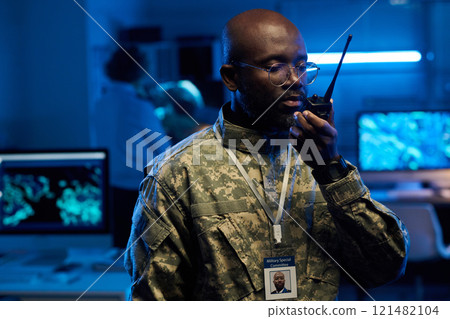 Serious man speaking in walkie-talkie 121482104