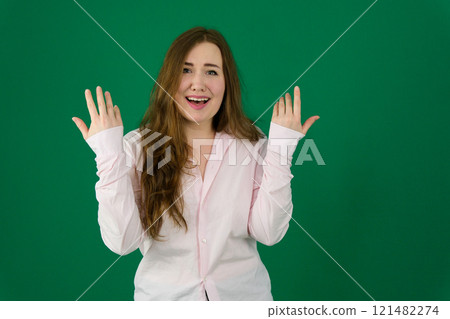 Photo of cheerful beautiful young woman standing isolated over white wall background. Looking camera showing winner gesture. Photo of cheerful beautiful young woman standing isolated over white wall background. Looking camera showing winner gesture. 121482274