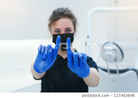 Selective focus on dental floss for dental care in the hands of smiling female dental hygienist 121483696