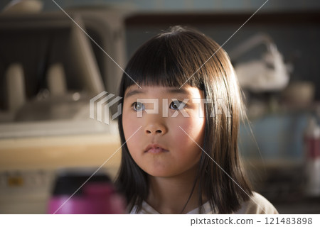 The expression of a girl sitting alone in a quiet room The expression of a girl sitting alone in a quiet room 121483898