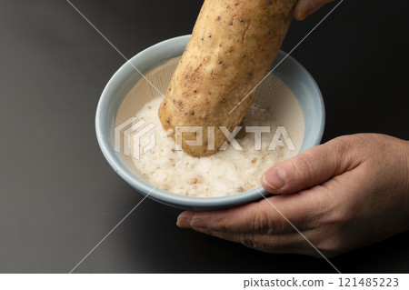 Grate the skinned yam in a mortar and pestle. Grate the skinned yam in a mortar and pestle. 121485223