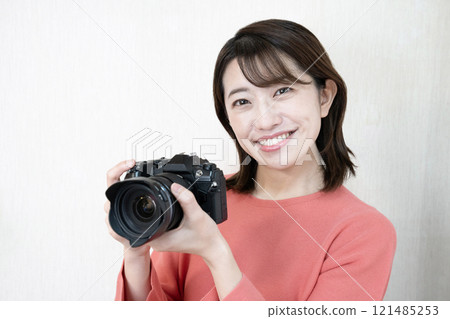 A woman smiling with a camera A woman smiling with a camera 121485253