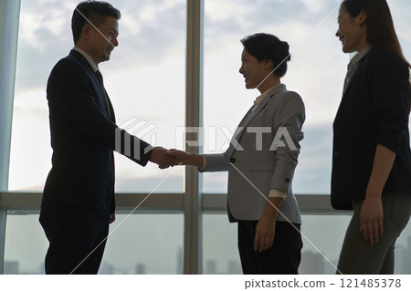 asian businesspeople shaking hands in office asian businesspeople shaking hands in office 121485378