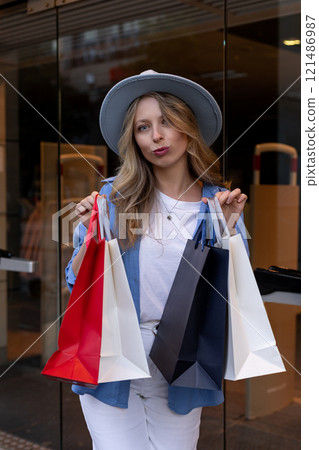 Young woman walking down street with bags after shopping. Shopping in the mall Young woman walking down street with bags after shopping. Shopping in the mall 121486987