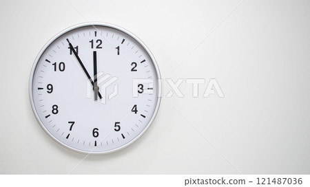 Minimalist White Clock with Silver Frame Striking 23.55/11.55 on White Background. Perfect for Time Management and Corporate Campaigns 121487036