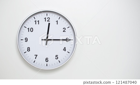 Minimalist White Clock with Silver Frame Striking 12.15/00.15 on White Background. Perfect for Time Management and Corporate Campaigns Minimalist White Clock with Silver Frame Striking 12.15/00.15 on White Background. Perfect for Time Management and Corporate Campaigns 121487040