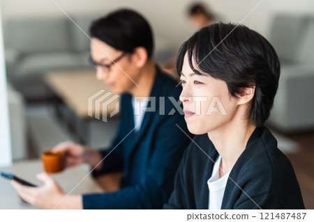 在咖啡館工作的年輕人，面對窗戶 121487487