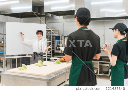A female instructor and male and female students at a chef's seminar/study group A female instructor and male and female students at a chef's seminar/study group 121487840