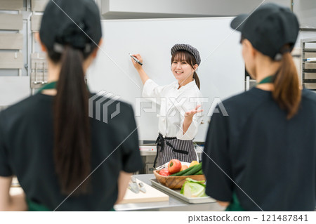 A female instructor teaching at a chef's seminar/study group 121487841