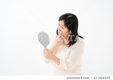 Senior woman looking in the mirror worries 121488105