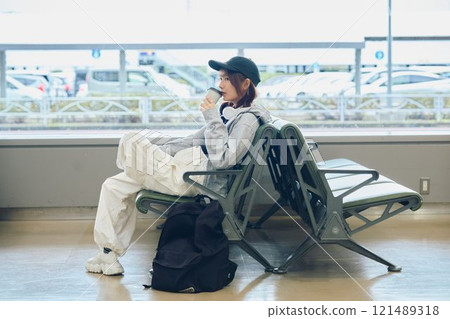 A woman in Y2K fashion waiting at the airport 121489318