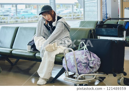 A woman in Y2K fashion waiting at the airport A woman in Y2K fashion waiting at the airport 121489359