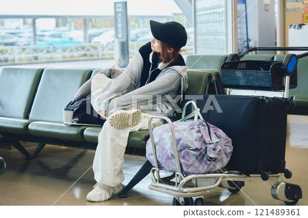 A woman in Y2K fashion waiting at the airport A woman in Y2K fashion waiting at the airport 121489361