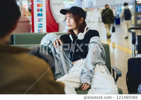 A woman in Y2K fashion waiting at the airport 121489366
