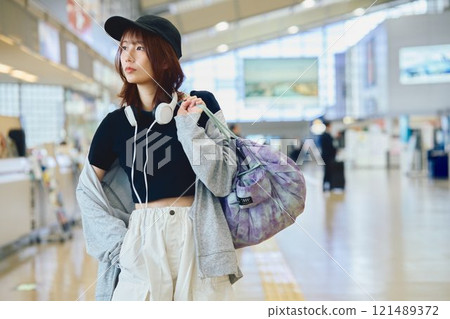 A woman in Y2K fashion walking through an airport 121489372