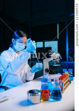 Female scientist working with micro pipettes analyzing biochemical samples, advanced science chemical laboratory 121489554