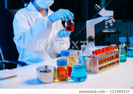 Scientist mixing chemical liquids in the chemistry lab. Researcher working 121489557
