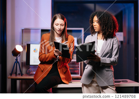 Kind leader executive manager share and discuss business solutions plan ideas on tablet with African female marketing manager. neon light in dark time. Kind leader executive manager share and discuss business solutions plan ideas on tablet with African female marketing manager. neon light in dark time. 121489708