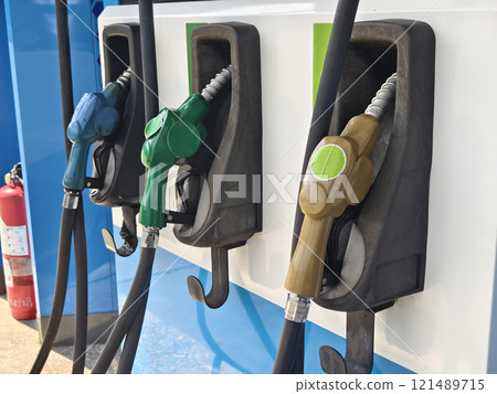 Fuel dispenser nozzles for various types of fuel, arranged at a gas station. Fuel dispenser nozzles for various types of fuel, arranged at a gas station. 121489715