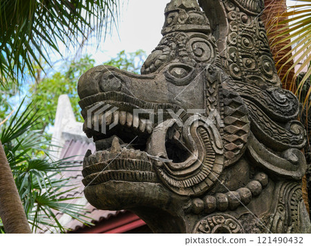 Stone carving of a dragon with open mouth 121490432