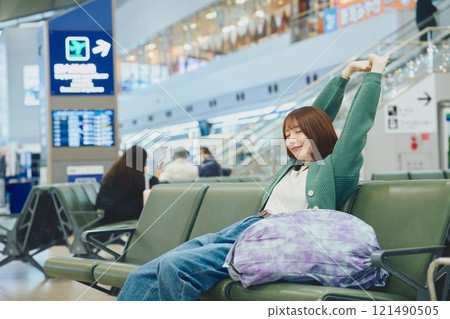 A woman about to embark on a solo trip waiting for boarding at the airport 121490505