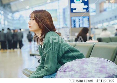 一位即將獨自旅行的女士在機場等待登機 一位即將獨自旅行的女士在機場等待登機 121490509