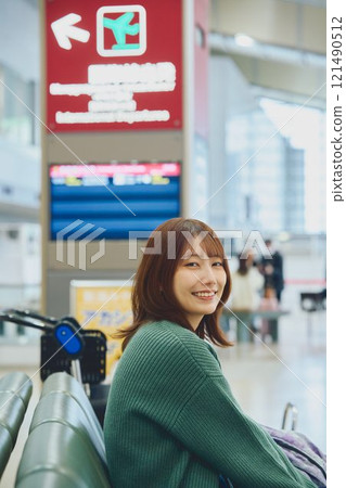 一位即將獨自旅行的女士在機場等待登機 一位即將獨自旅行的女士在機場等待登機 121490512