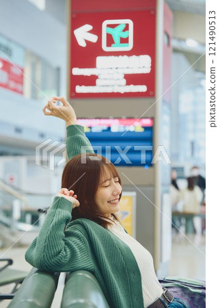 A woman about to embark on a solo trip waiting for boarding at the airport 121490513