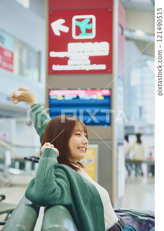 A woman about to embark on a solo trip waiting for boarding at the airport 121490515