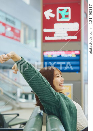 一位即將獨自旅行的女士在機場等待登機 一位即將獨自旅行的女士在機場等待登機 121490517