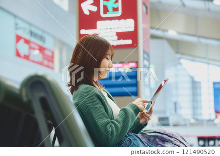 A woman about to embark on a solo trip waiting for boarding at the airport 121490520
