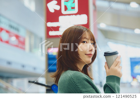 一位即將獨自旅行的女士在機場等待登機 一位即將獨自旅行的女士在機場等待登機 121490525