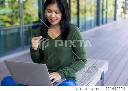 Business woman working from coffee shop using laptop online meeting in home office, Business woman typing keyboard use notebook laptop Smiling, laughing at coffee shop relaxation table. Business woman working from coffee shop using laptop online meeting in home office, Business woman typing keyboard use notebook laptop Smiling, laughing at coffee shop relaxation table. 121490554