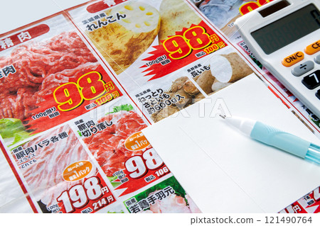 Image of taking note of special offers while looking at a newspaper insert flyer 121490764