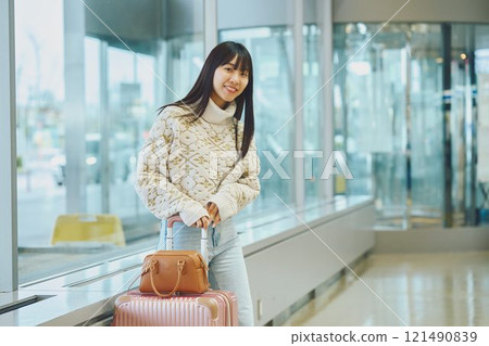 A woman in an airport lobby about to embark on a solo trip 121490839