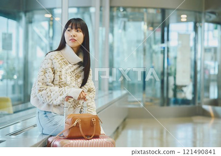 A woman in an airport lobby about to embark on a solo trip 121490841