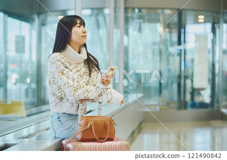A woman in an airport lobby about to embark on a solo trip 121490842