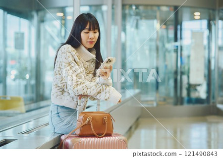 A woman in an airport lobby about to embark on a solo trip 121490843