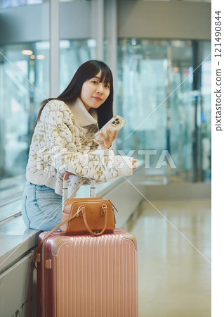 機場大廳裡一位準備獨自旅行的女士 機場大廳裡一位準備獨自旅行的女士 121490844