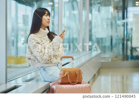 A woman in an airport lobby about to embark on a solo trip 121490845